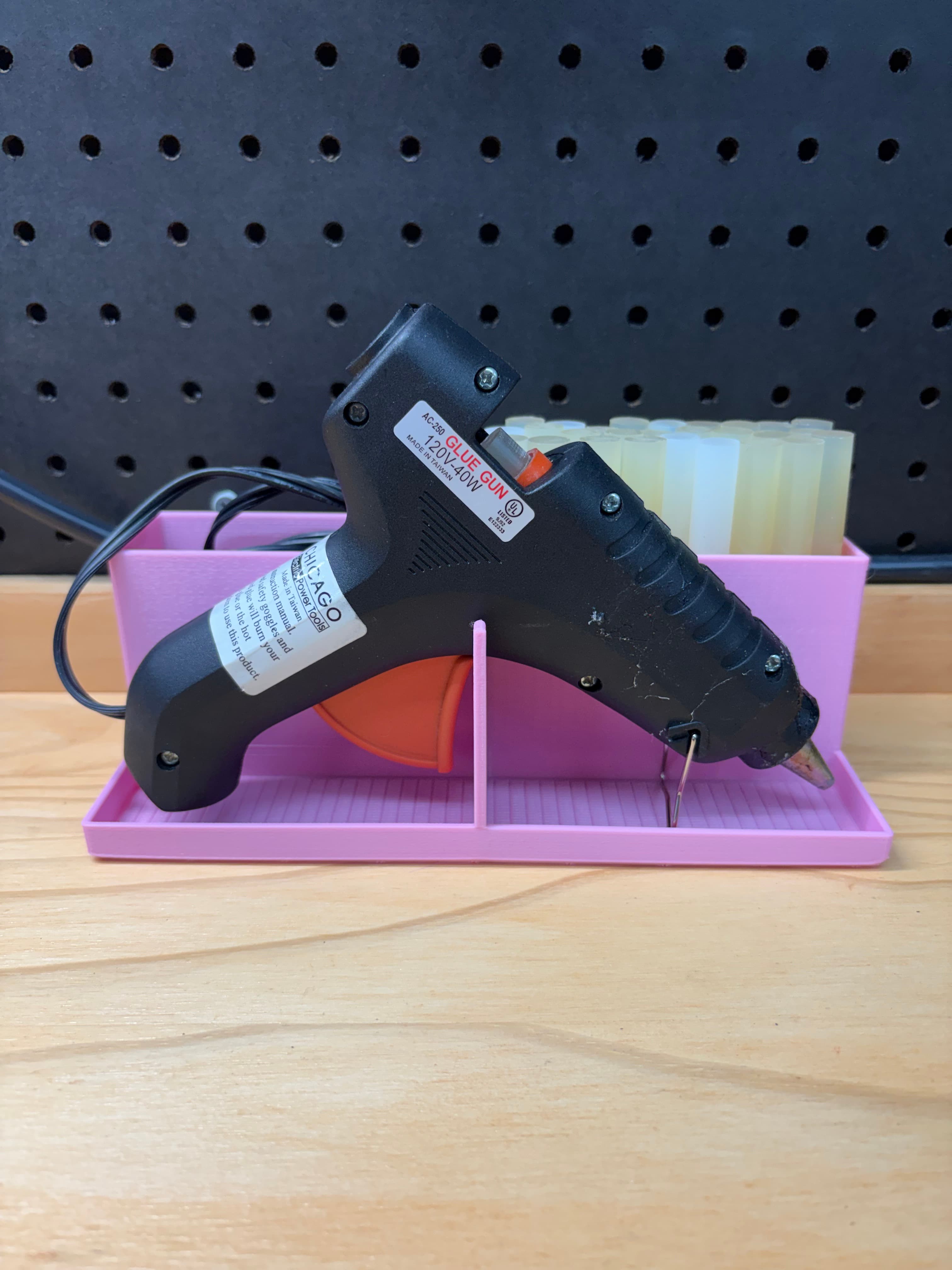 Pink 3D printed large hot glue gun station with full-size glue gun resting in tray