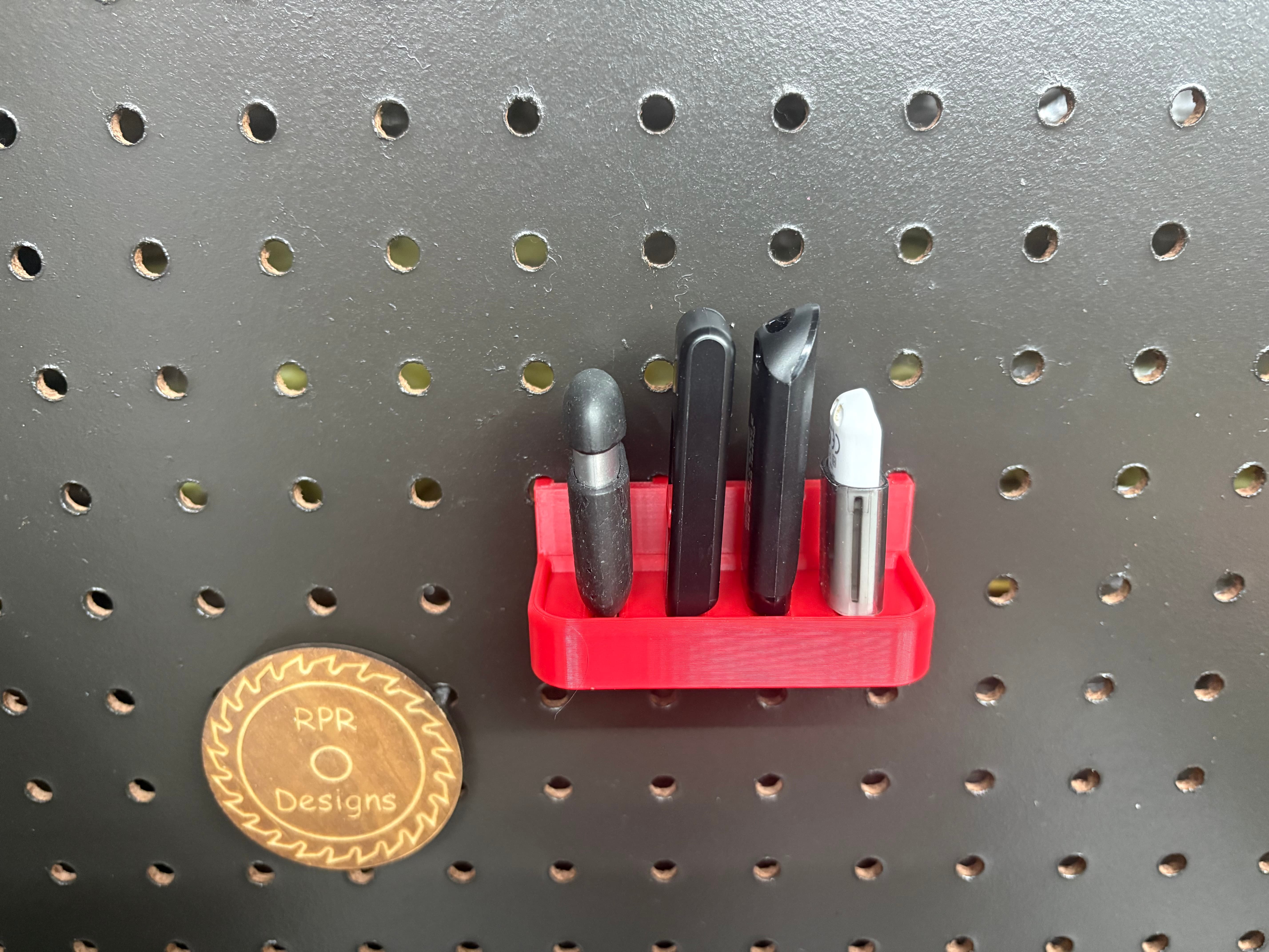 Red 3D printed USB drive holder with 4 slots mounted on a pegboard